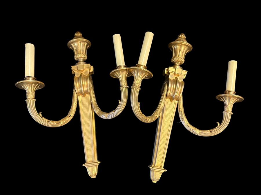 Pair of large Louis XVI-style bronze wall sconces, 19th century High-quality bronze wall sconces, chiselled, featuring an elegant design with two light points and a vase crowning the ensemble Dimensions: Height: 62 cm Width: 42 cm Depth: 22 cm