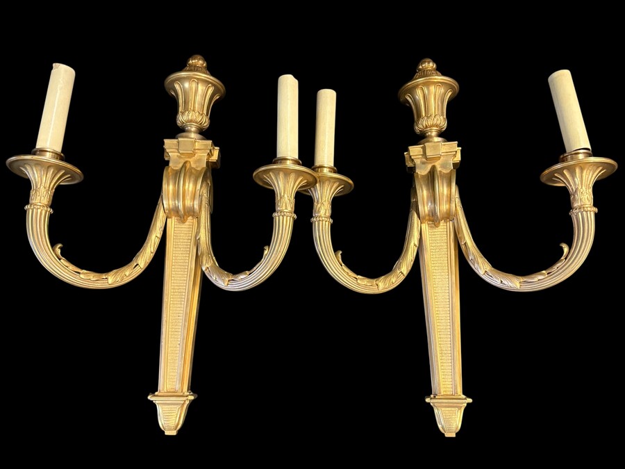 Pair of large Louis XVI-style bronze wall sconces, 19th century High-quality bronze wall sconces, chiselled, featuring an elegant design with two light points and a vase crowning the ensemble Dimensions: Height: 62 cm Width: 42 cm Depth: 22 cm