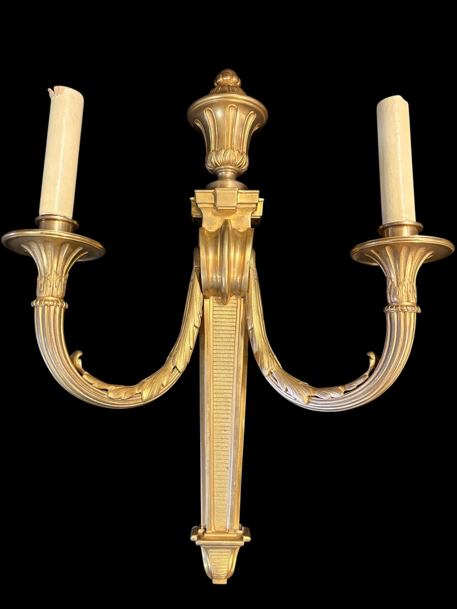 Pair of large Louis XVI-style bronze wall sconces, 19th century High-quality bronze wall sconces, chiselled, featuring an elegant design with two light points and a vase crowning the ensemble Dimensions: Height: 62 cm Width: 42 cm Depth: 22 cm