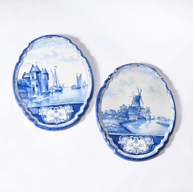 Pair of large Makkum earthenware wall plates Highly decorative blue and white earthenware wall plates depicting Dutch landscapes with windmills, water, boats, houses and animals. Fitted with a hanging loop and marked on the back. 