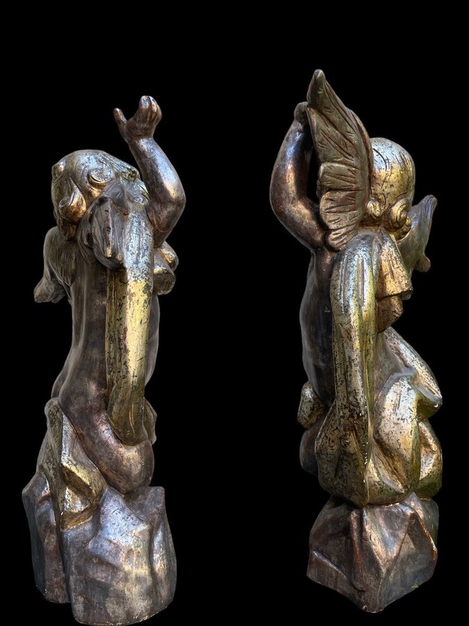 Pair of large silver/golden wood angels circa 1900. Decorative wooden angels in good condition. Dimensions: Height: 81 and 84 cm Width : 47 and 54 cm Depth : 24 and 25 cm Sculptures from Italy circa 1900