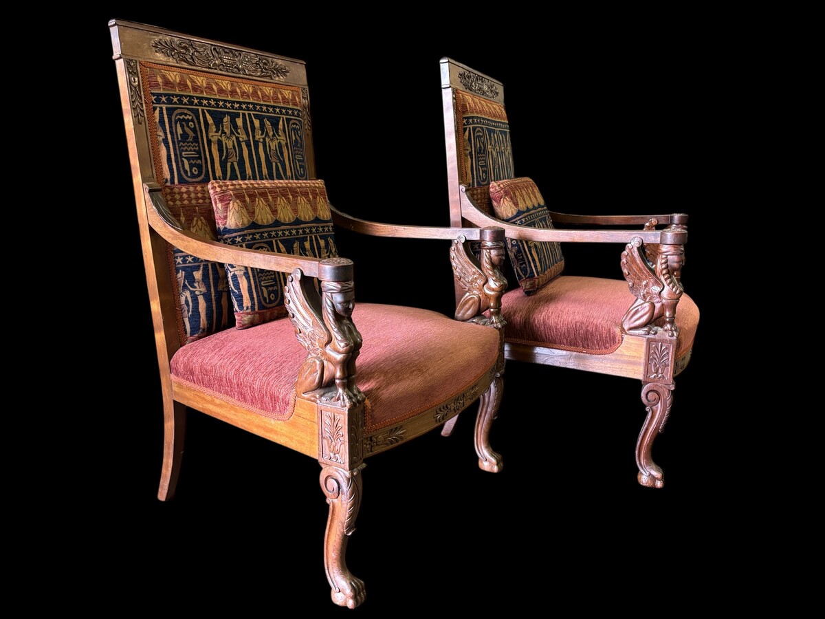 Pair of large walnut armchairs in the 19th century Empire style Armchairs decorated with carved wooden sphinxes and Empire decorations and fitted with a beautiful fabric tapestry and a cushion with Egyptian representations. 