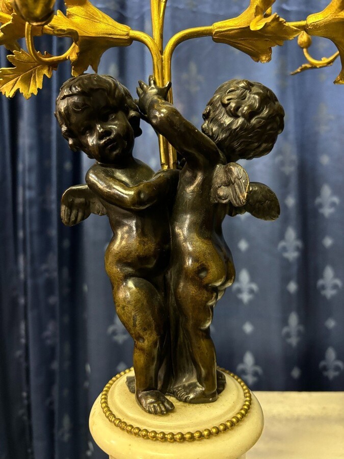 Pair of Napoleon III ‘2 angels’ bronze candelabras. Nice 19thC. candelabra representing a pair of angels carrying 3 gilt bronze candelabra with sprigs of flowers resting on a white marble base.