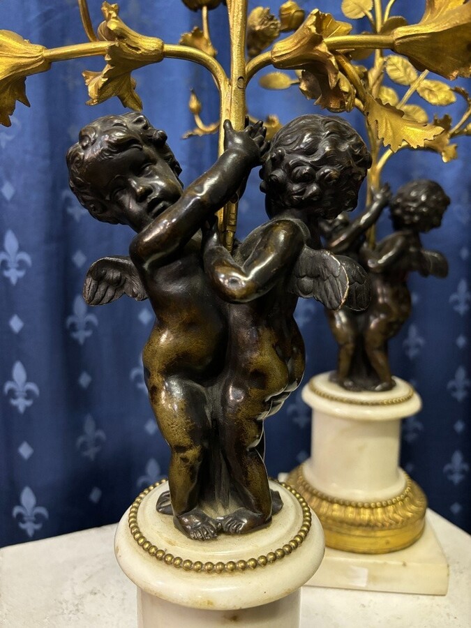 Pair of Napoleon III ‘2 angels’ bronze candelabras. Nice 19thC. candelabra representing a pair of angels carrying 3 gilt bronze candelabra with sprigs of flowers resting on a white marble base.