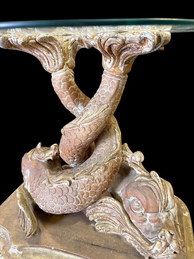 Pair of wooden coffee tables, ‘Mythological Fish,’ late 19th century. Highly decorative coffee tables depicting two intertwined fish, finely carved and featuring a round glass top.In good condition