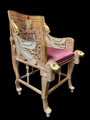 Tutankhamun throne in gilded and patinated wood 21th C. A highly decorative gilded wooden throne with a silk fabric cushion ‘after’ the throne from the tomb of Tutankhamun.Tutankhamun, pharaoh of ancient Egypt