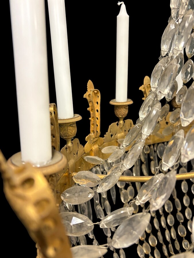 Very large Empire-style ‘pearl bag’ chandelier, circa 1900 A magnificent large ‘pearl bag’ chandelier featuring a decorated crown and border, as well as 12 gilded bronze candle holders.