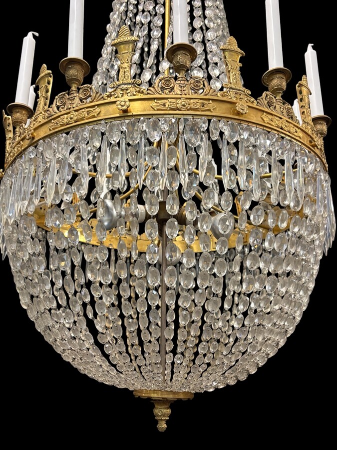 Very large Empire-style ‘pearl bag’ chandelier, circa 1900 A magnificent large ‘pearl bag’ chandelier featuring a decorated crown and border, as well as 12 gilded bronze candle holders.