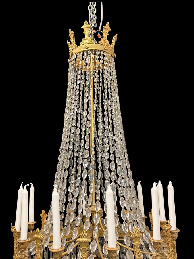 Very large Empire-style ‘pearl bag’ chandelier, circa 1900 A magnificent large ‘pearl bag’ chandelier featuring a decorated crown and border, as well as 12 gilded bronze candle holders.