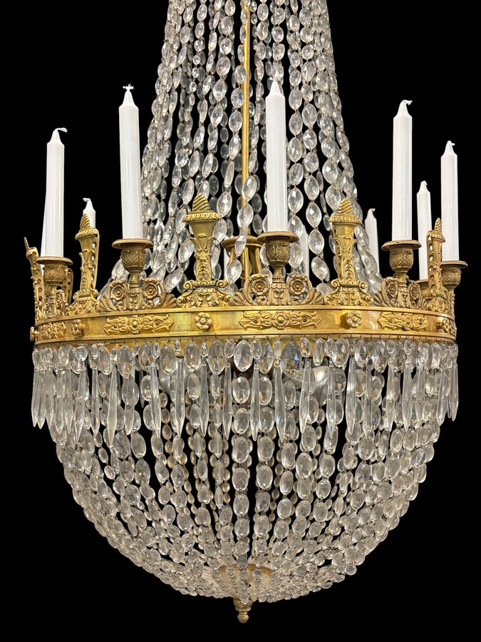 Very large Empire-style ‘pearl bag’ chandelier, circa 1900 A magnificent large ‘pearl bag’ chandelier featuring a decorated crown and border, as well as 12 gilded bronze candle holders.