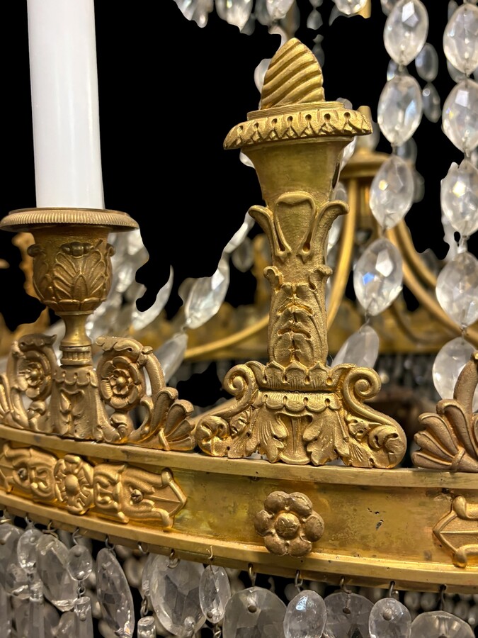 Very large Empire-style ‘pearl bag’ chandelier, circa 1900 A magnificent large ‘pearl bag’ chandelier featuring a decorated crown and border, as well as 12 gilded bronze candle holders.