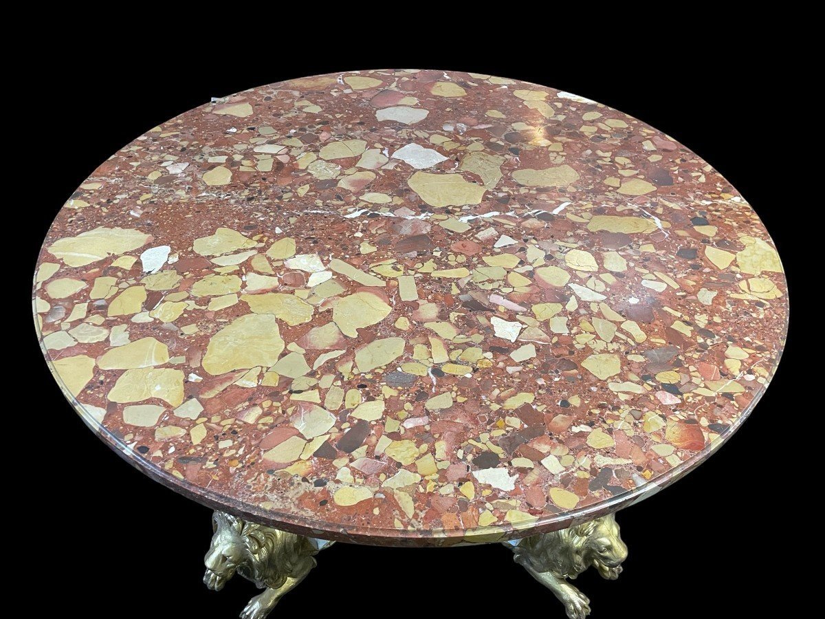 White and Gold Carved Wooden Table With Round Top In Breche d'Alep Marble. A white and gold carved wooden centre table with a round Breche d'Alep marble top resting on a central quadrangular shaft underlined by four inverted consoles and panels