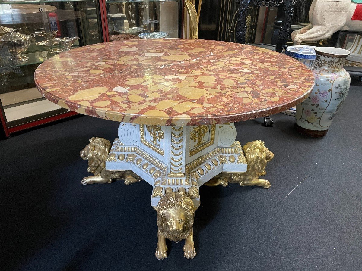 White and Gold Carved Wooden Table With Round Top In Breche d'Alep Marble. A white and gold carved wooden centre table with a round Breche d'Alep marble top resting on a central quadrangular shaft underlined by four inverted consoles and panels